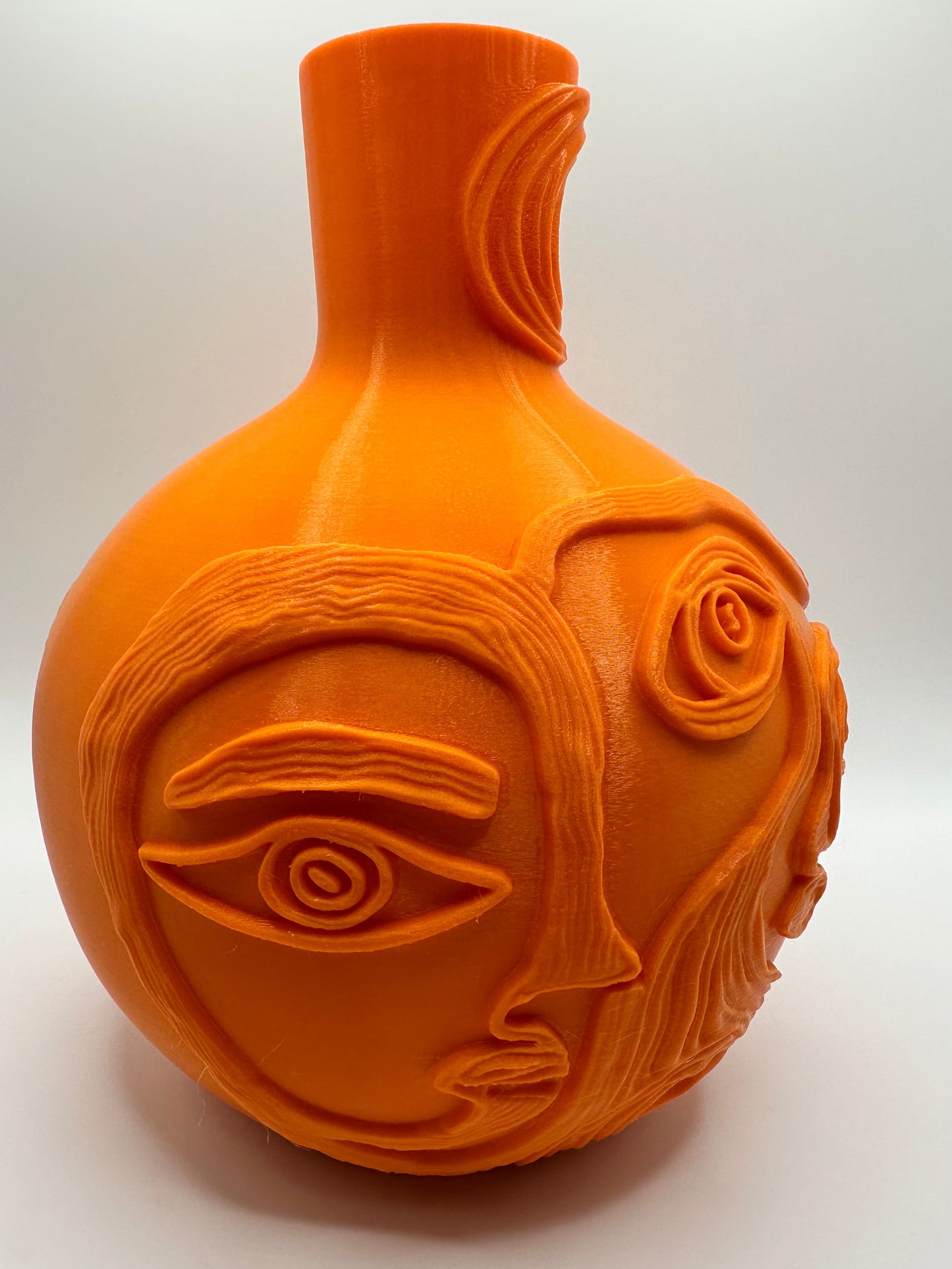 3D printed abstract faces vase displayed with tulips on a modern white table