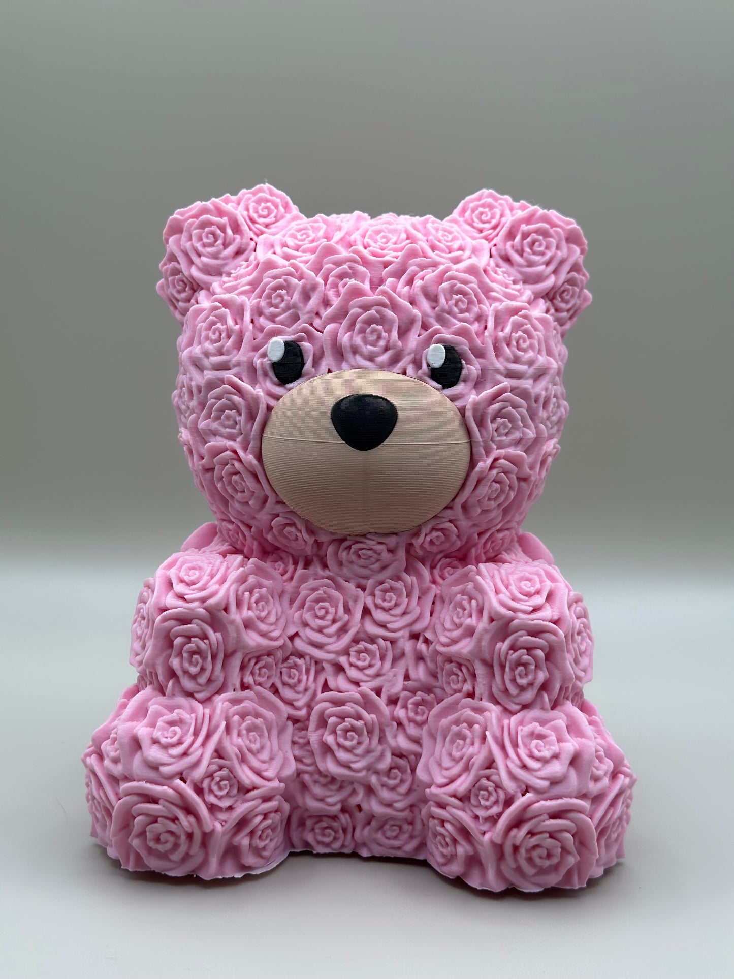 3D printed teddy bear sculpture covered in pink roses