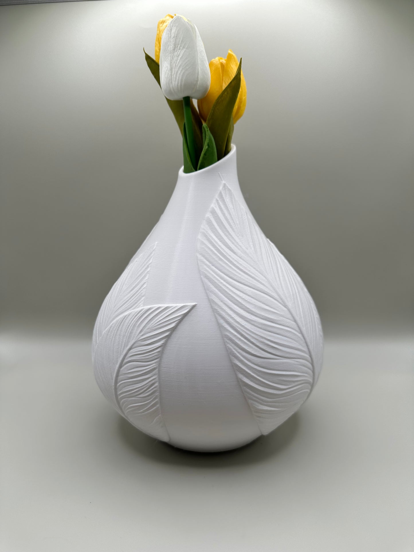 Sculptural leaf vase with yellow flowers on a wooden table