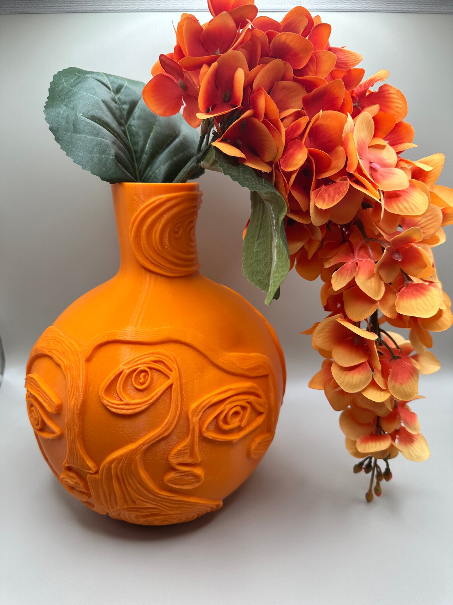 Orange vase with orange flowers
