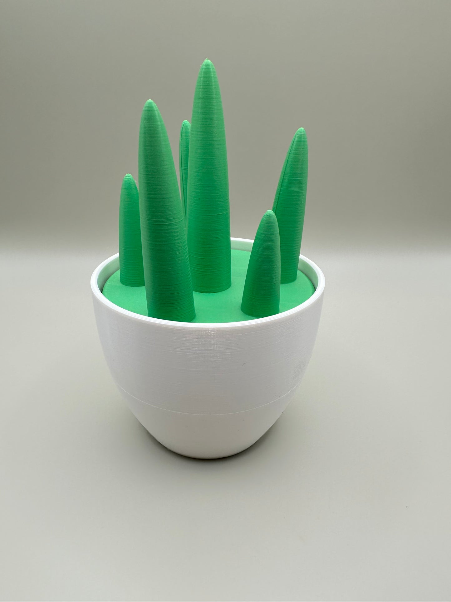3D printed green and white jewelry holder with forest-inspired cone tops