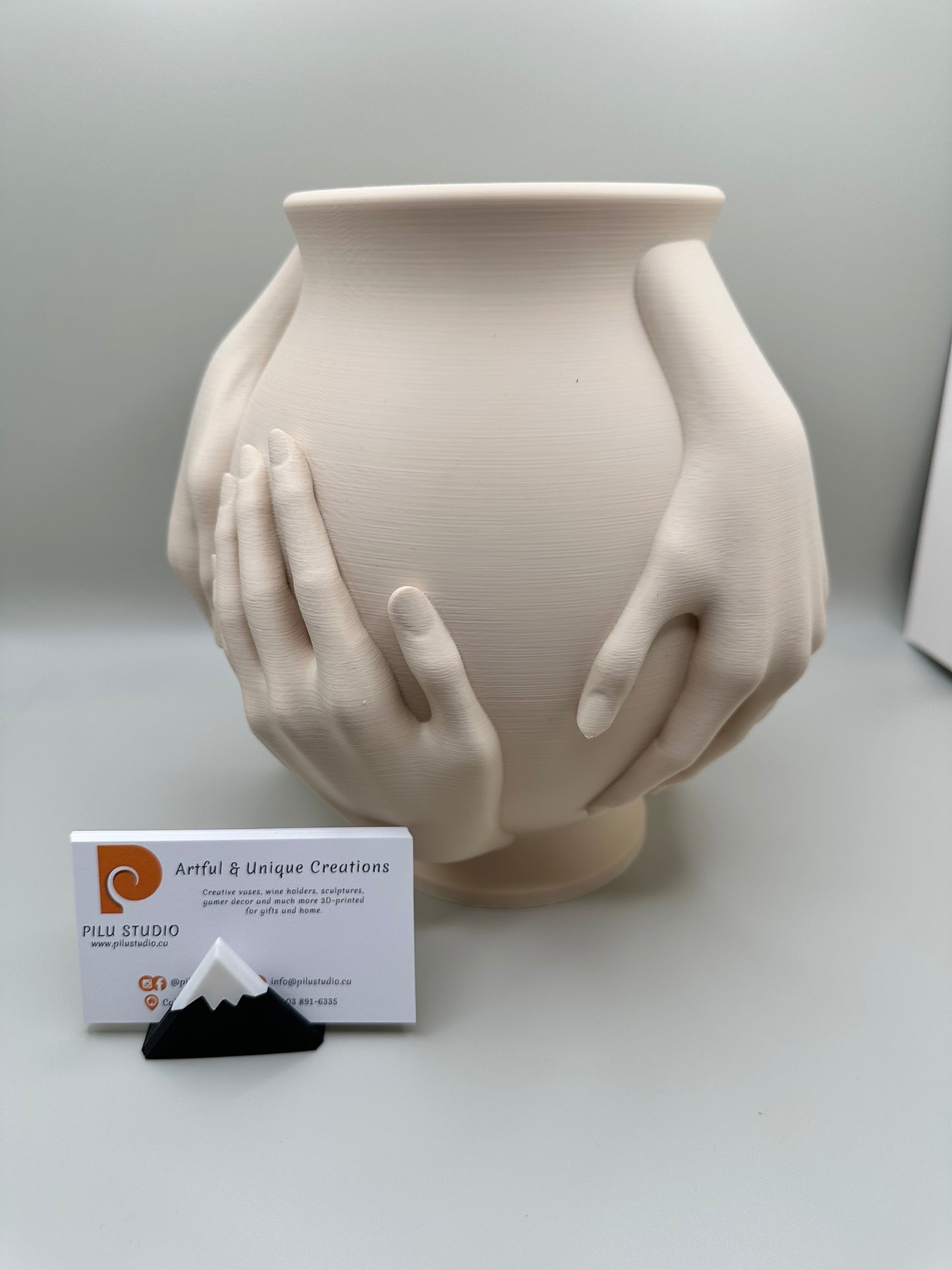 3D printed vase embraced by sculptural hands in minimalist style