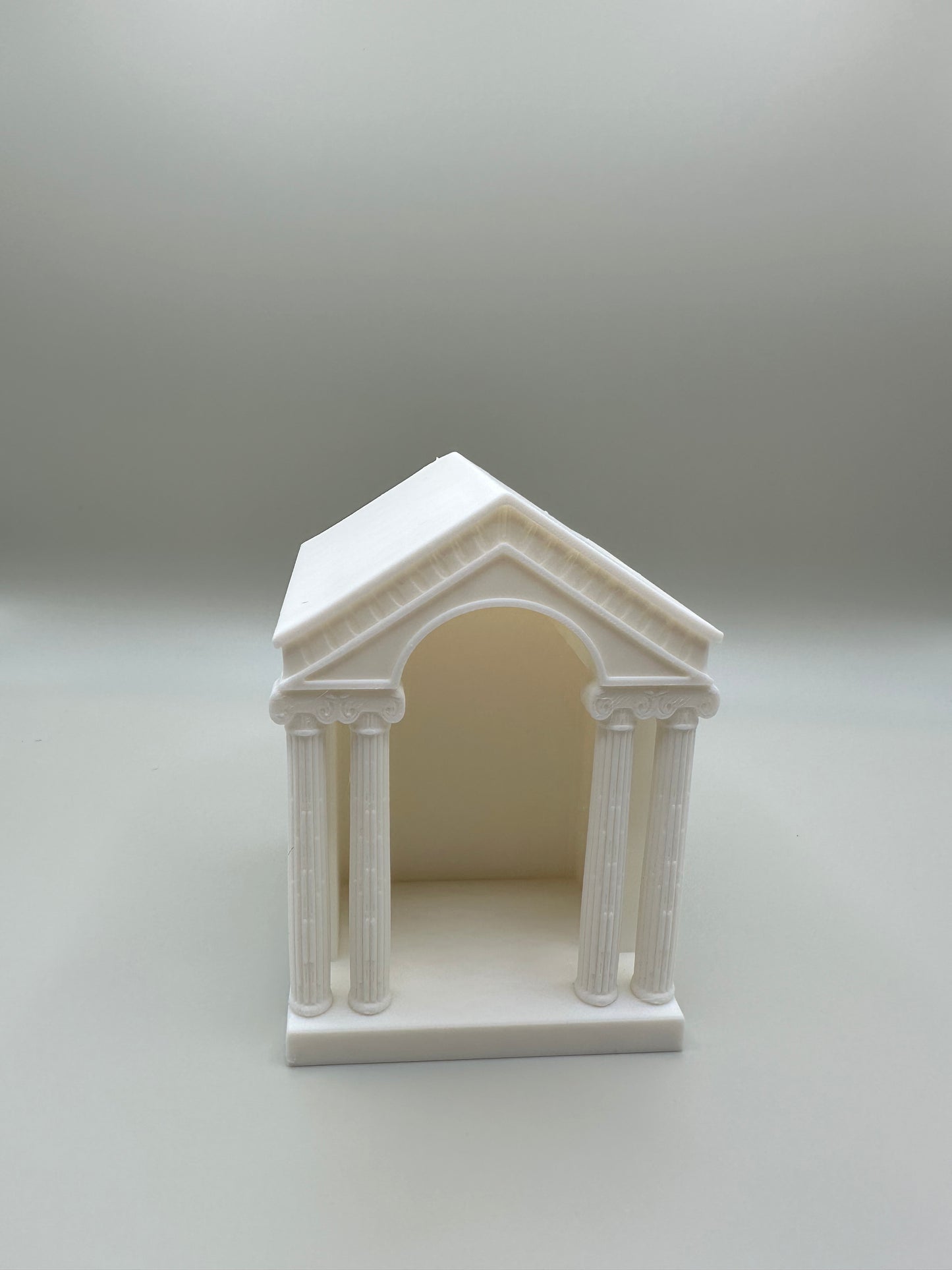 Classical architectural candle holder with columns and arch design
