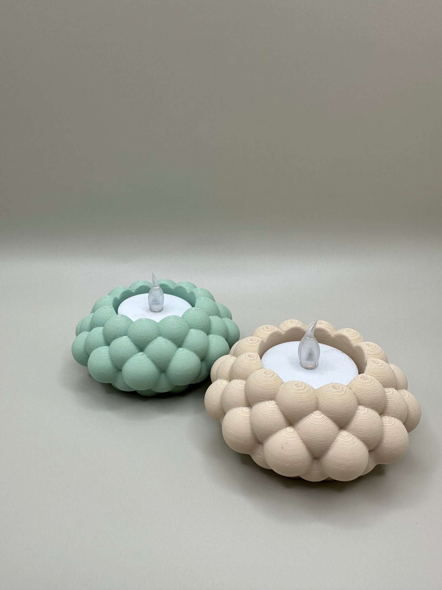 Pair of cozy 3D printed tealight holders designed with soft bubble texture.