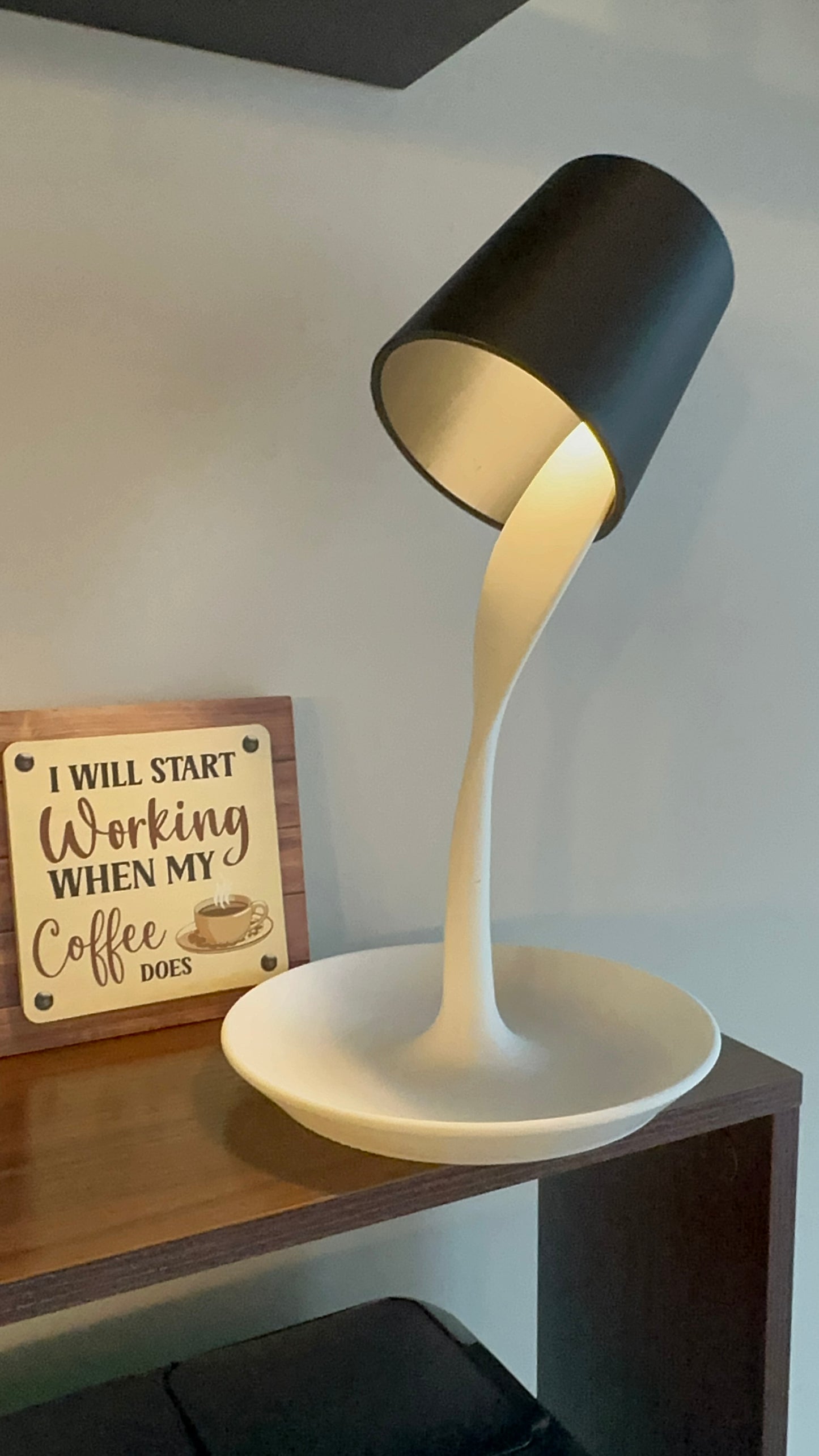 3D printed spill-effect lamp with LED light and remote, placed on a wooden table