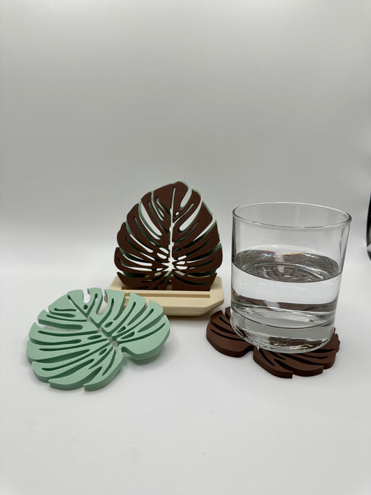 3D printed monstera leaf coasters in layered green with holder