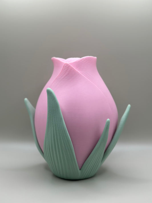3D printed pink vase shaped like a rose with green sculpted leaves
