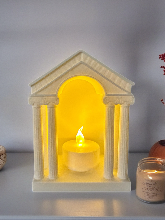 3D printed temple-style candle holder glowing with LED light on a shelf