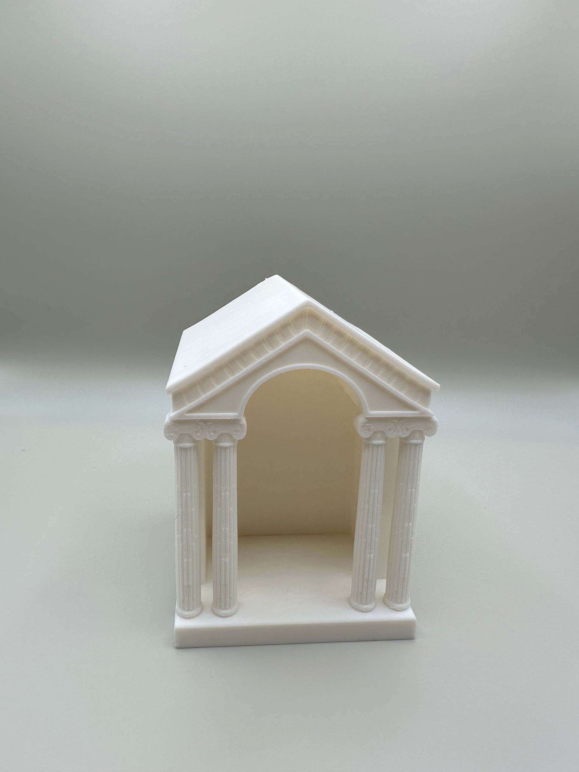 Classical architectural candle holder with columns and arch design